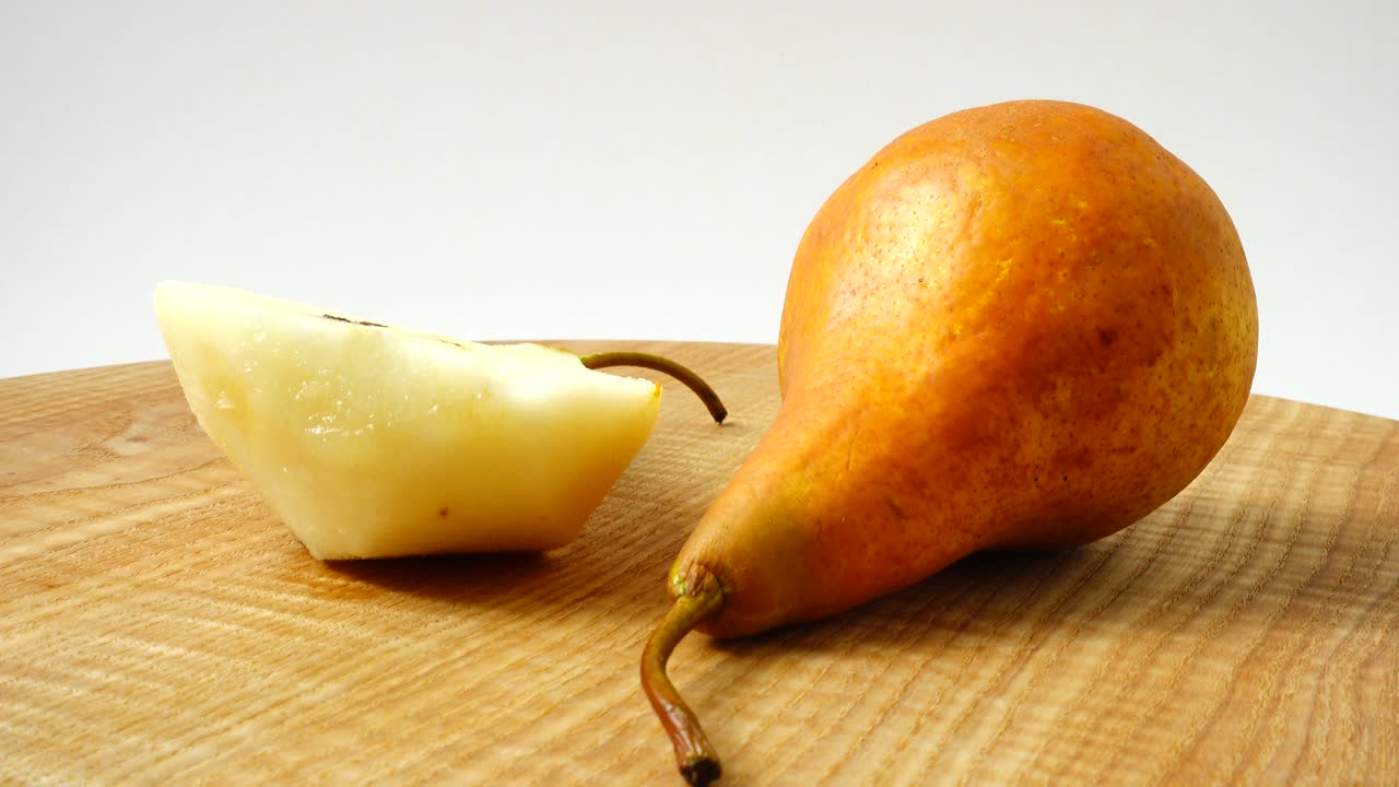 Pere su un tagliere di legno in cucina. Ripresa in movimento