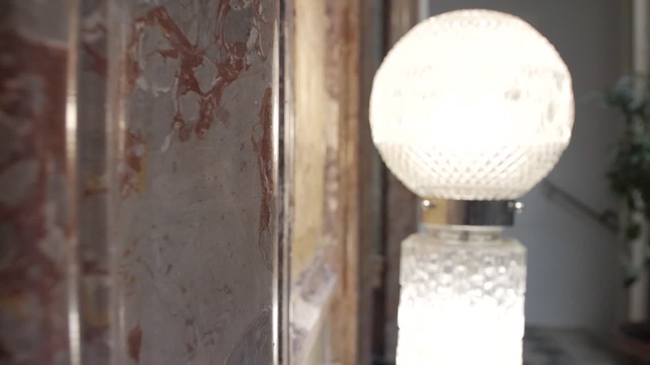 밝은 크리스탈 조명이 방을 비추는 멋진 대리석 벽의 클로즈업 샷