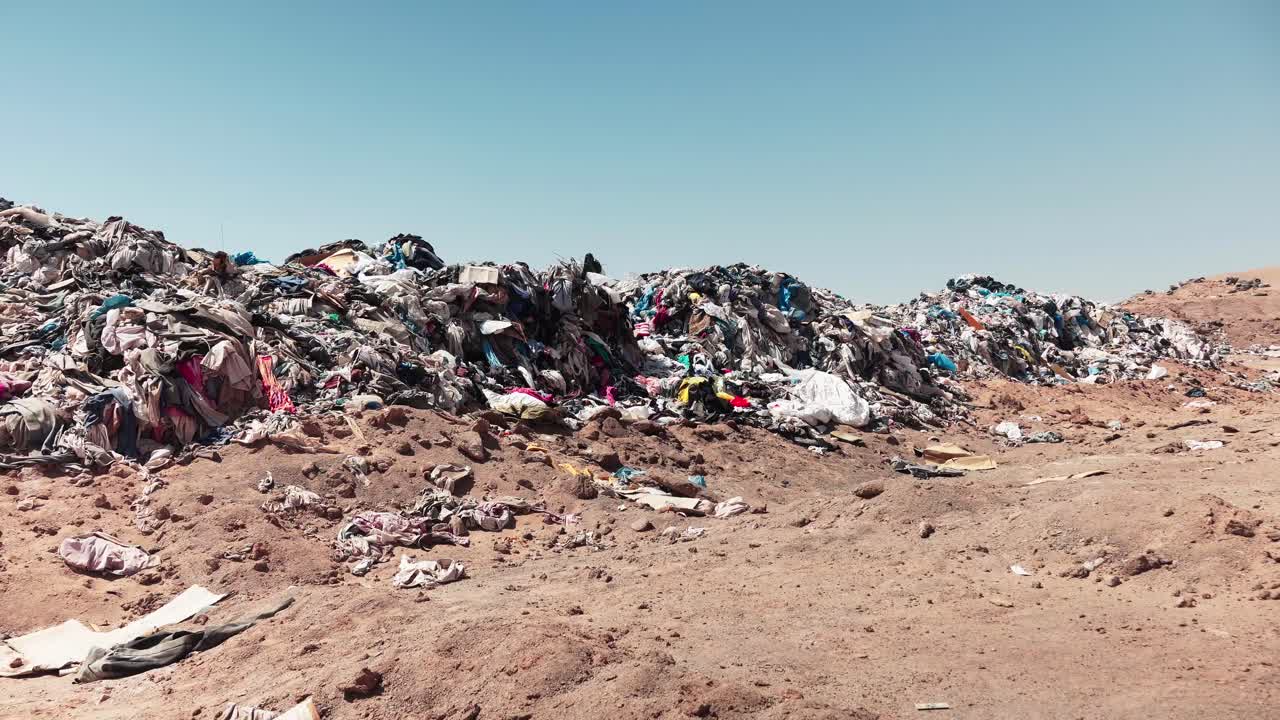 acumulación de ropa de segunda mano en vertederos clandestinos generando un vertedero de basura en el desierto chileno