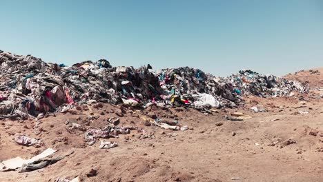 acumulación de ropa de segunda mano en vertederos clandestinos generando un vertedero de basura en el desierto chileno