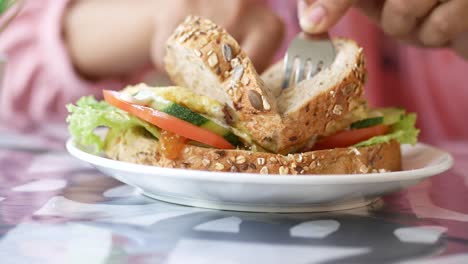 primer plano de una persona comiendo un delicioso sándwich de trigo entero