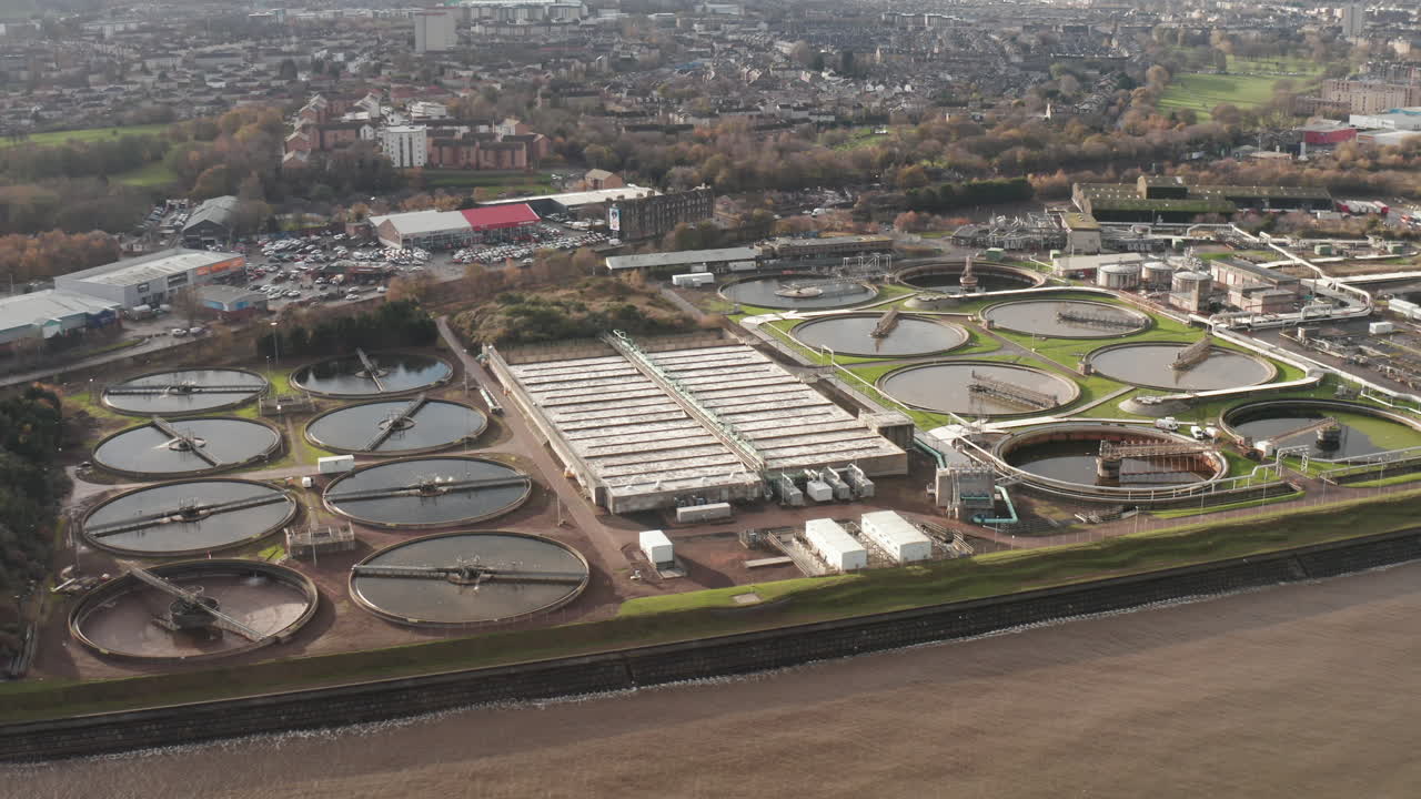 Aerial shot flying over a sewage plant as the wastewater rushes below