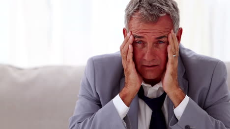 Troubled-businessman-sitting-on-a-sofa-