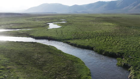 aerial view of winding river peacefully meanders through lush green fields