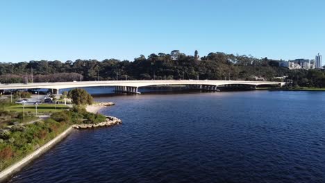 Drone-Aerial-View-of-South-Perth-foreshore-along-Swan-River-ascending-over-Narrows-Bridge-with-Freeway-to-Kings-Park