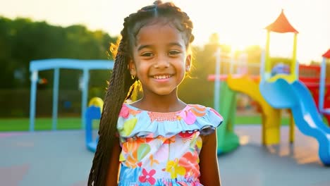 a little girl smiling happily on a playground