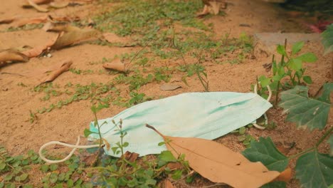 Discarded-Surgical-Mask-On-the-Ground-with-Soil-and-Leaves