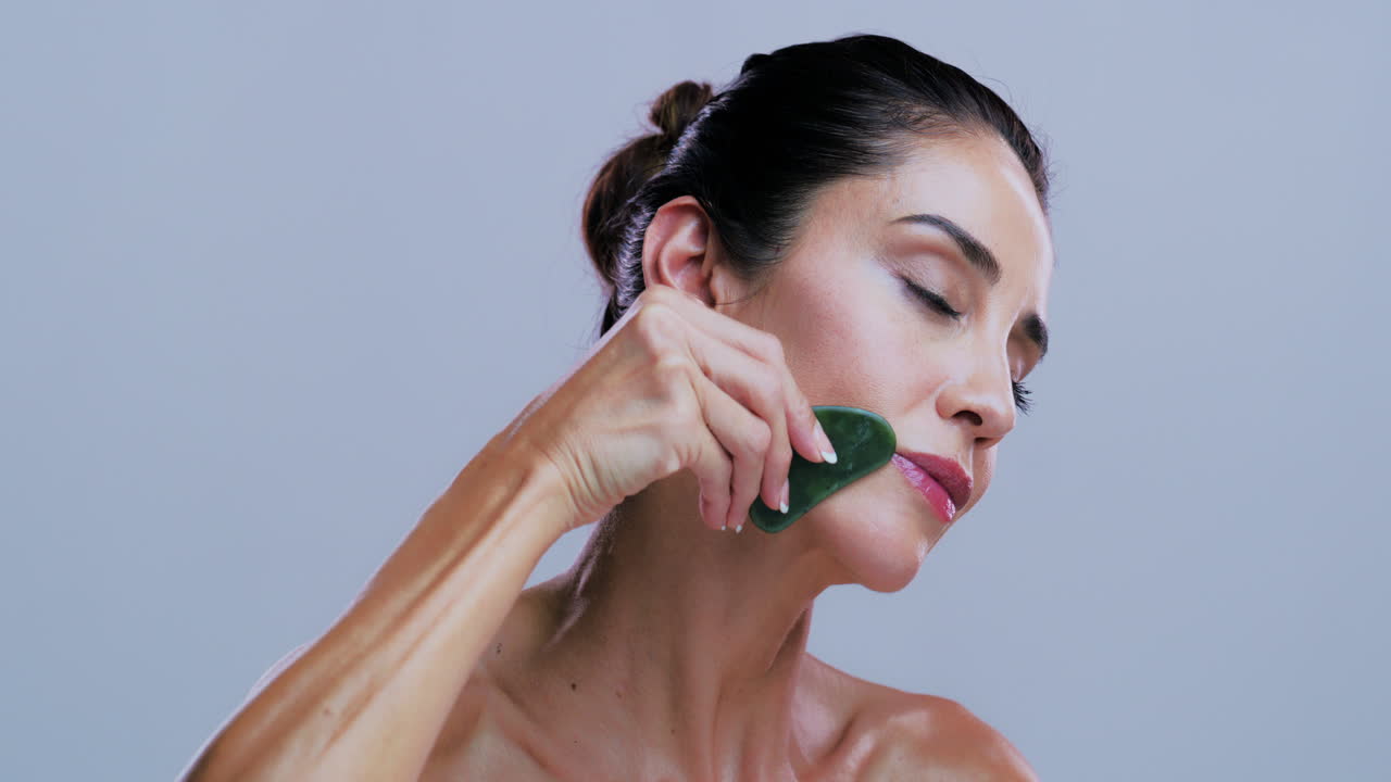 Kvinde bruger Gua Sha til ansigtsmassage