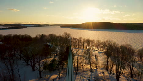 Picturesque-winter-aerial-view-of-a-church-steeple-against-the-light-of-the-setting-sun