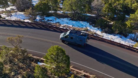 Recreational-Vehicle-Driving-Across-The-Road-In-Dense-Snow-Forest-Near-Grand-Canyon-National-Park-In-Arizona,-USA