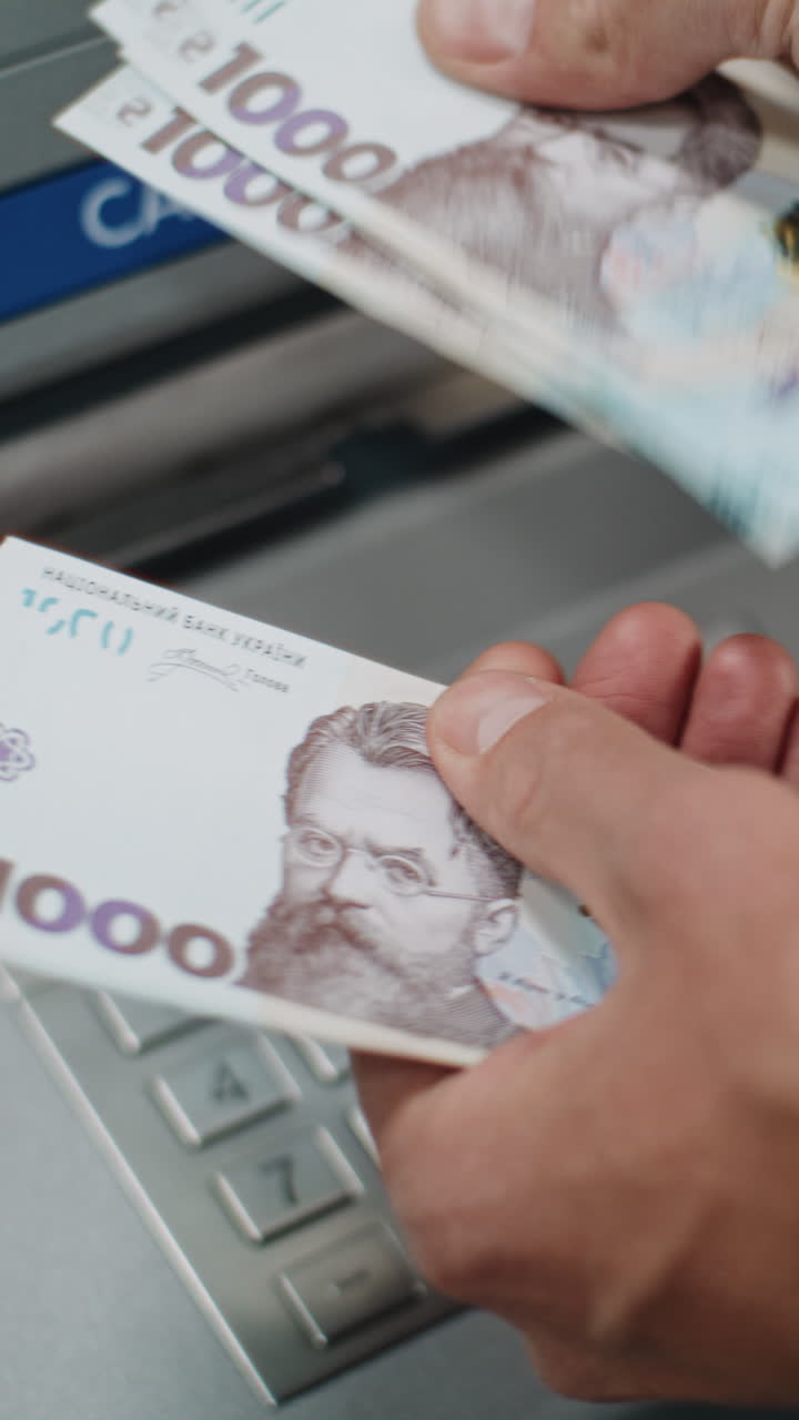 человек, снимающий деньги из банкомата