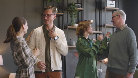 happy family posing and looking at camera while standing in a modern living room at home