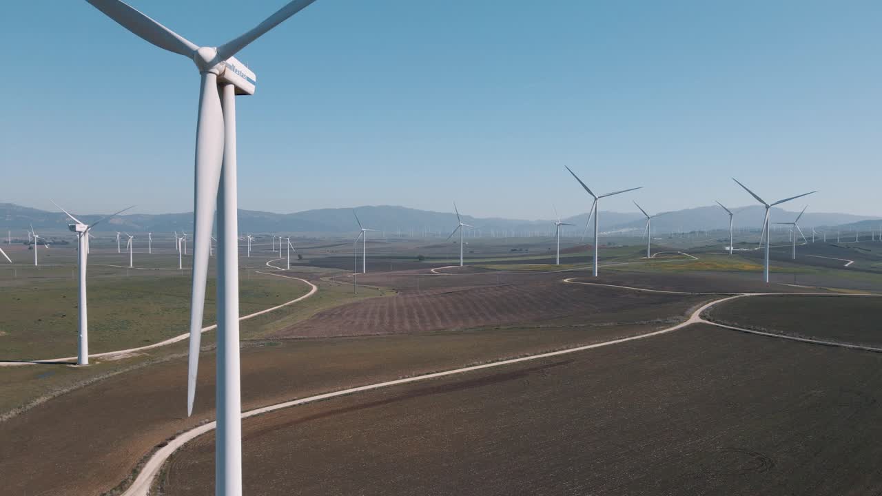 subiendo turbinas eólicas de energía renovable de giro lento en la vista aérea del paisaje del parque eólico