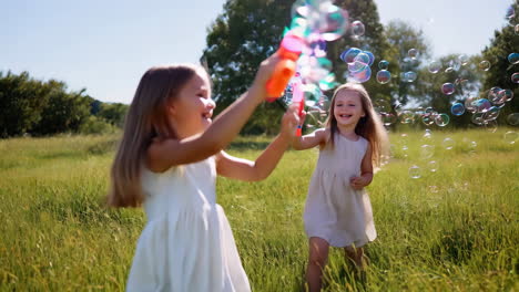 two happy girls playing with bubble guns and bubbles in a sunny field