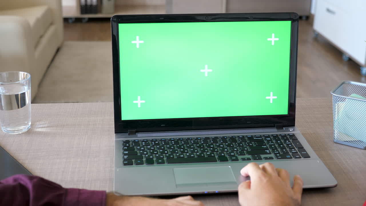 portátil con pantalla verde en el escritorio