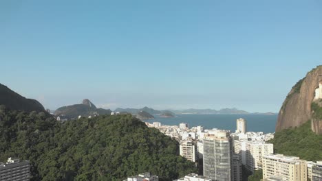 Langsame-Luftbewegung-Vorwärts-Mit-Hohen-Wohngebäuden-Im-Vordergrund-Und-Copacabana-Viertel-In-Rio-De-Janeiro-Mit-Dem-Zuckerhut-Im-Hintergrund