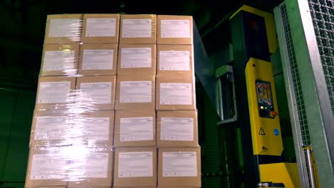 una máquina vertical que cubre cajas giratorias con envoltura.