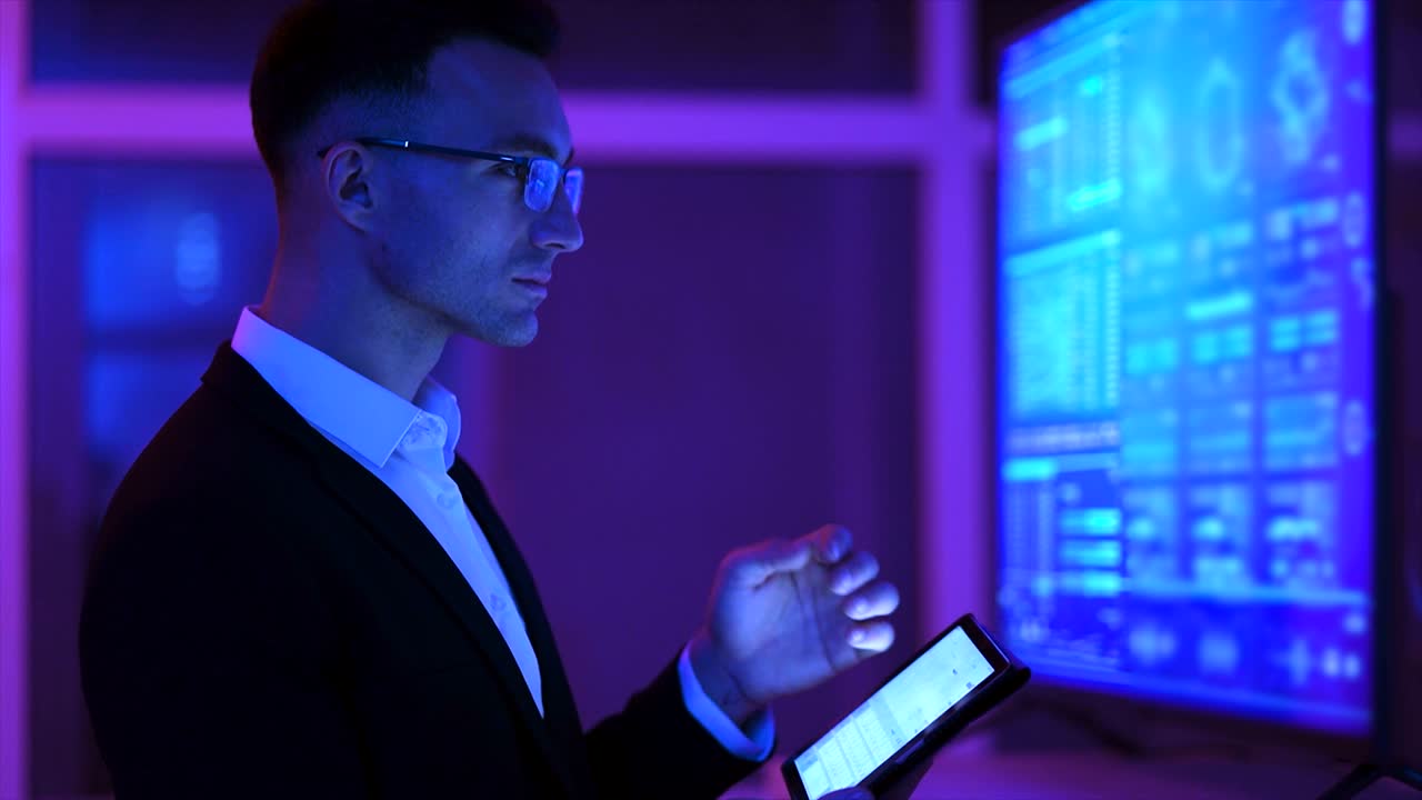 The man working with a tablet near a big screen