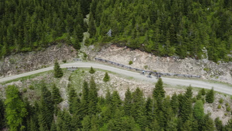 Grupo-De-Ciclistas-Montando-Bicicletas-En-Carretera-De-Montaña-En-Moravia,-Chequia,-Drone