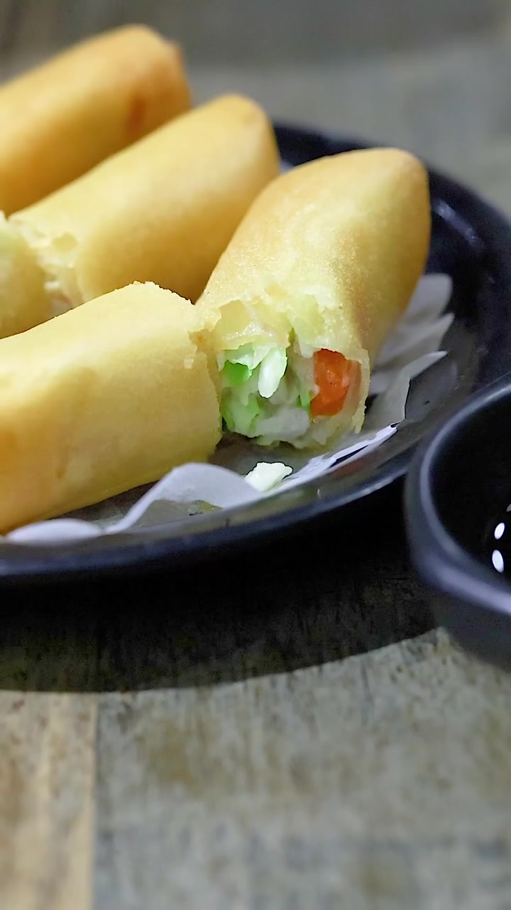 Sepiring lumpia dengan saus celup kecap.