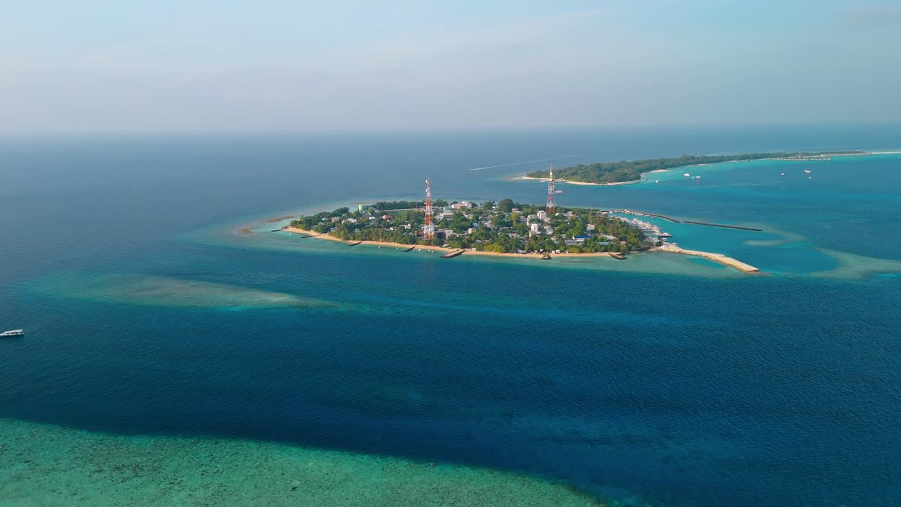 A breathtaking aerial drone view captures Rasdhoo Island bathed in the warm glow of sunset in the Maldives.
