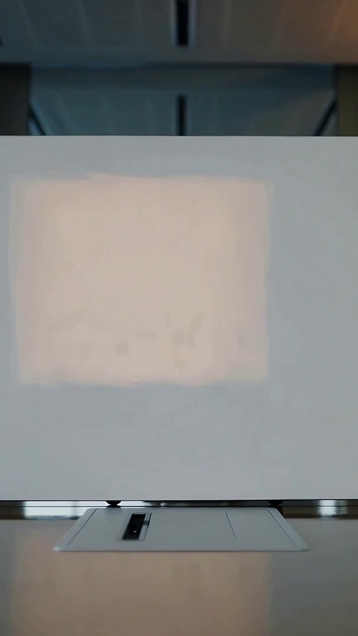 Vertical video: Projector powering on to show slides, screen showing spot fading in meeting room