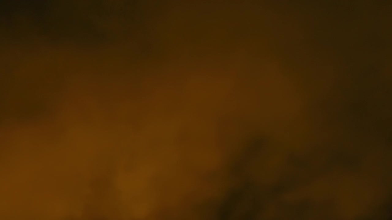 Movimento rallentato di fumo di vapore arancione che fuoriesce all'aria aperta con sfondo nero. Filmato con telecamera cinematografica. Ideale per aggiungere texture ai tuoi video. Usare la modalità Add o Screen.