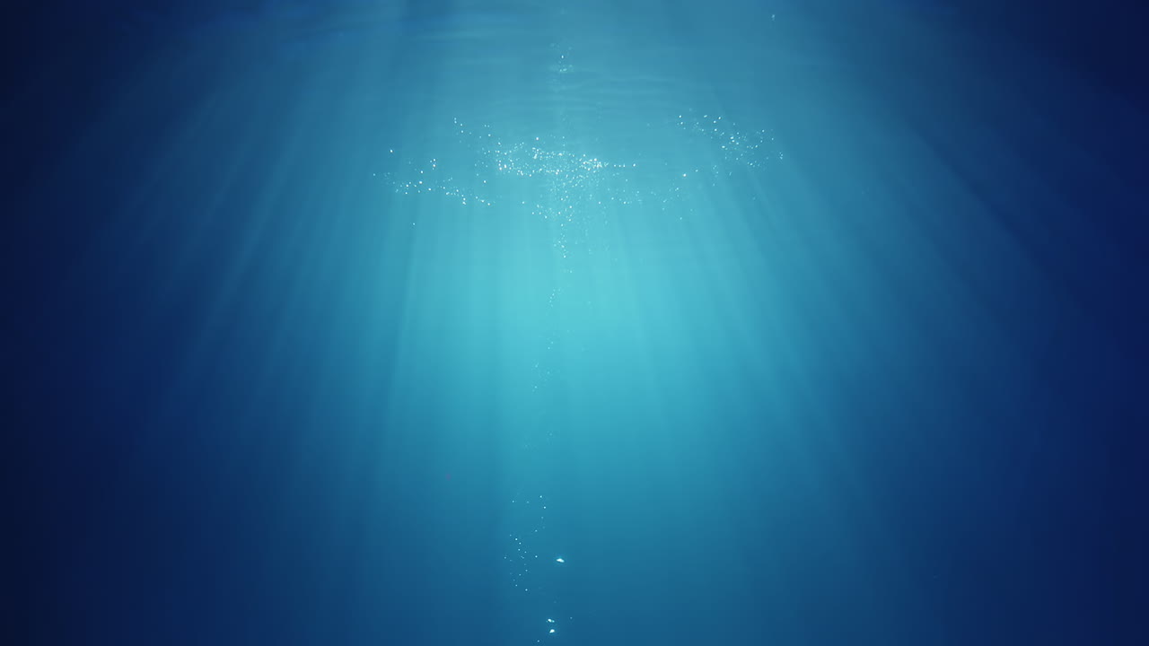 위에서 빛나는 수중 햇빛 광선이 깊고 맑은 푸른 물을 통해 아름다운 물 조명 반사 커튼을 만듭니다.