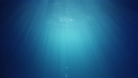 underwater sunlight beams shining from above coming through the deep crystal clear blue water causing a beautiful water lighting reflections curtain