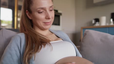 Mujer-Embarazada-Relajándose-Con-Un-Cachorro-En-El-Sofá