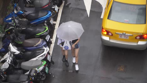 girls walking underneath umbrella