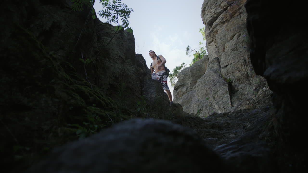 hombre en un sendero de senderismo rocoso, tipo deportivo senderismo saltos, montaña, camina por un sendero de montaña con el pecho desnudo, equipo de montañismo, escalada al aire libre, clima soleado de verano en austria, durnstein, europa