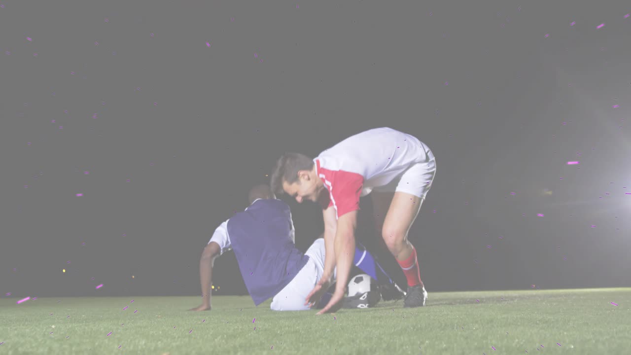 Soccer player 14 dribbling ball on lit turf evading tackle jumping colliding helping defender