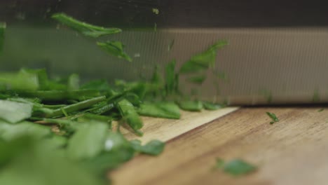 Close-up-of-chopping-flat-parley-with-a-knife-on-a-cutting-board