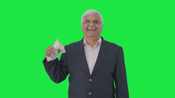 Happy Indian senior manager using money as fan Green screen