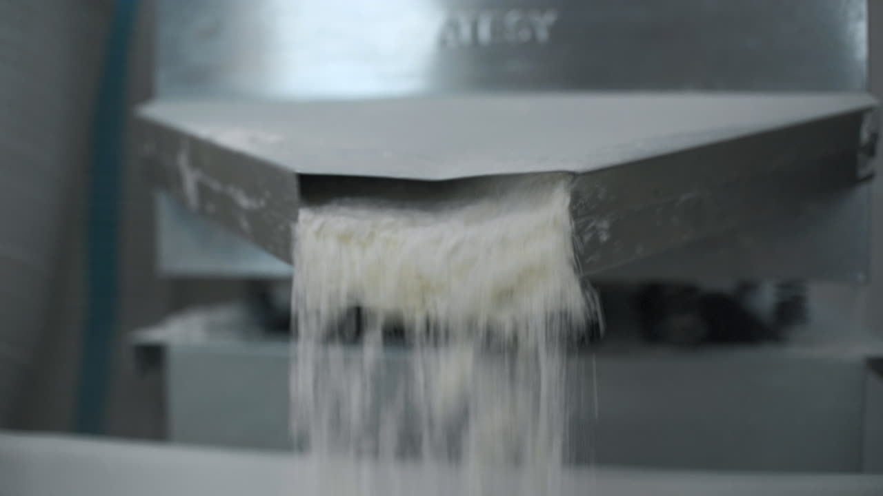 Powder Flowing from a Conveyor System in a Factory