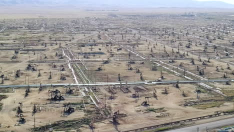 Large-oil-field-with-oil-wells,-establishing-aerial-shot