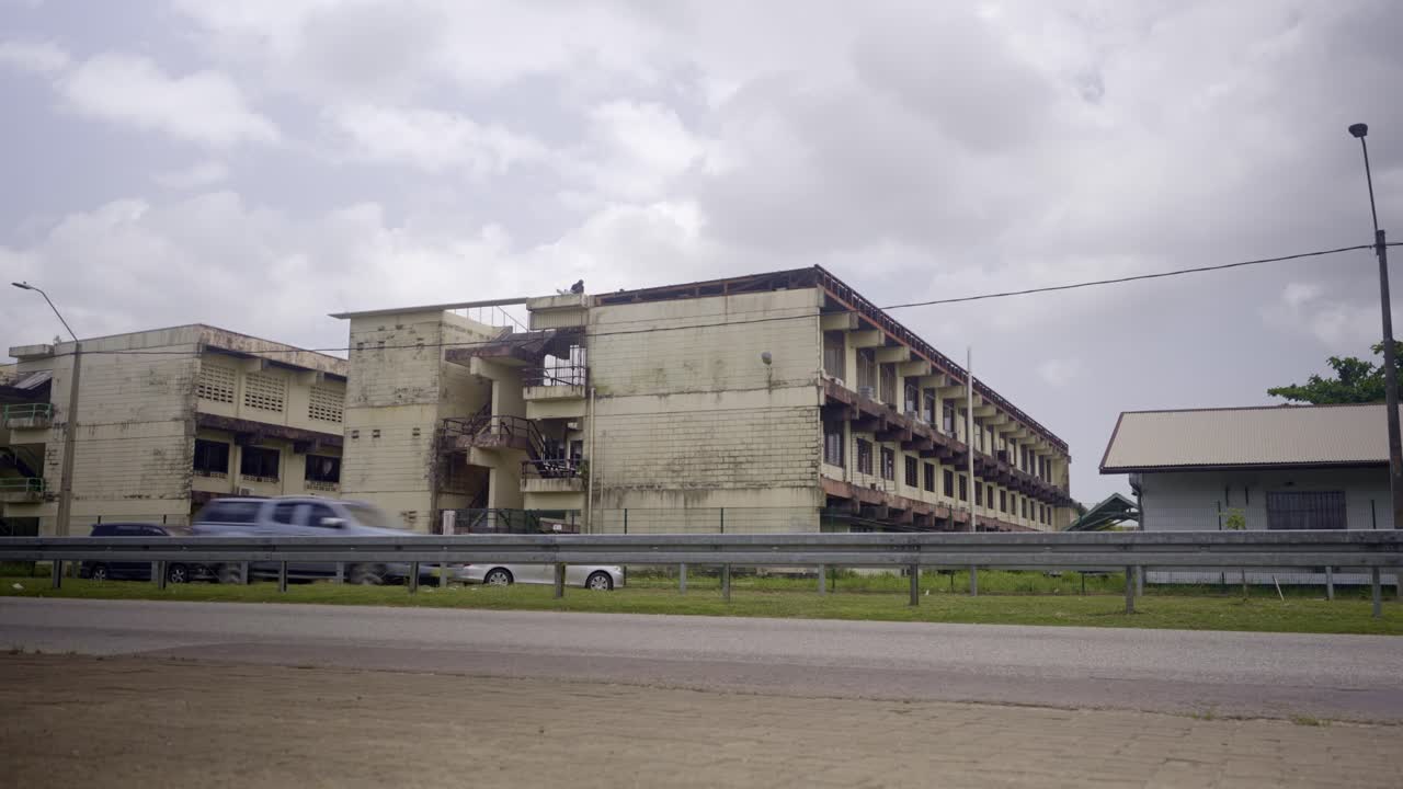Street view of Natin school building in Paramaribo Suriname, cars driving by
