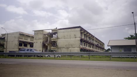 street view of natin school building in paramaribo suriname, cars driving by