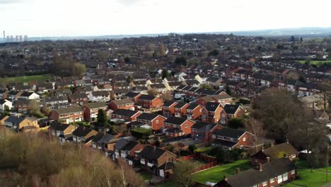 Rural-British-townhouse-neighbourhood-homes-with-green-space-aerial-view-across-to-Snowdonia-mountain-skyline,-Pan-right-shot