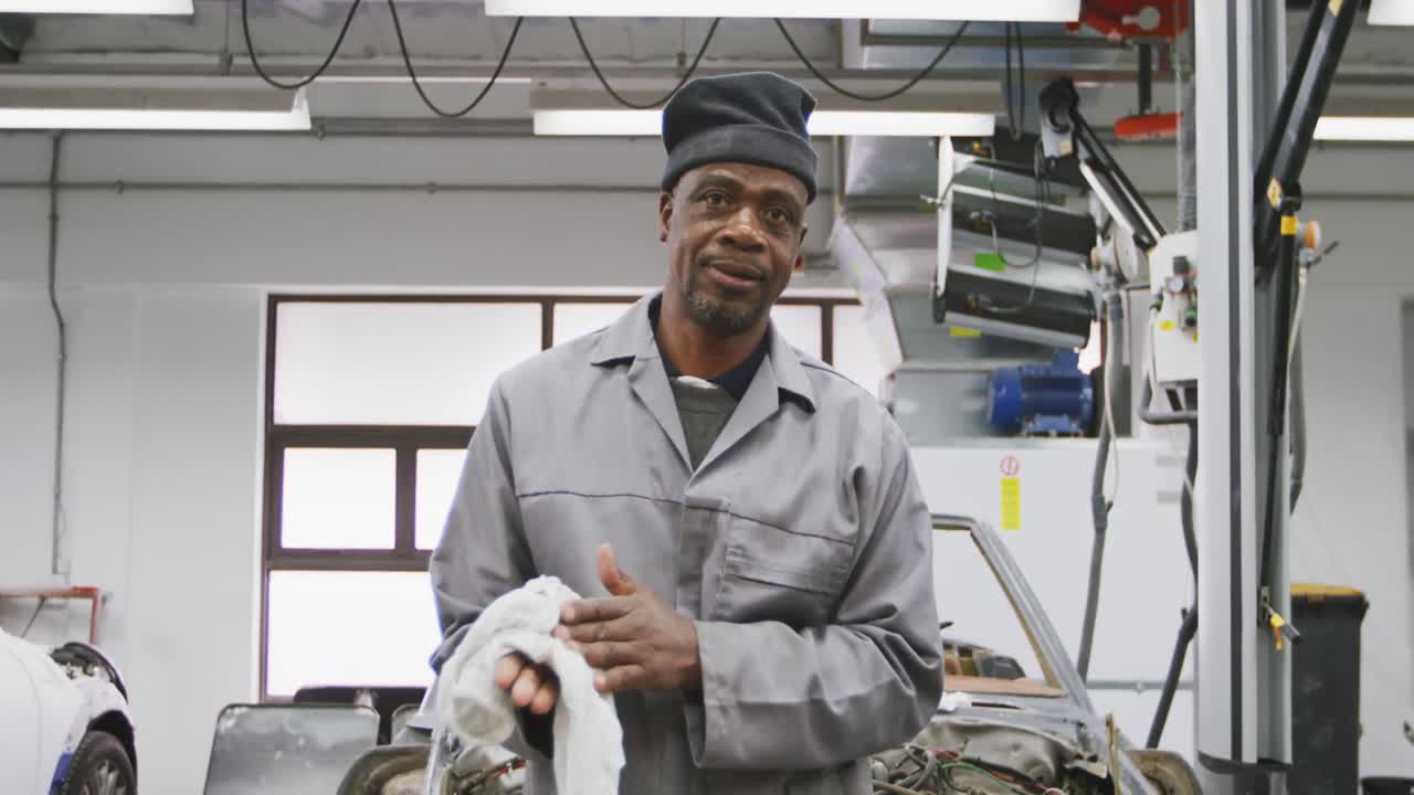 African american male car mechanic cleaning his hands with a rag ...