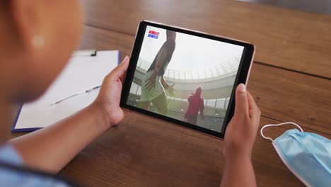 Composite-of-woman-on-couch-at-home-watching-rugby-match-on-tablet