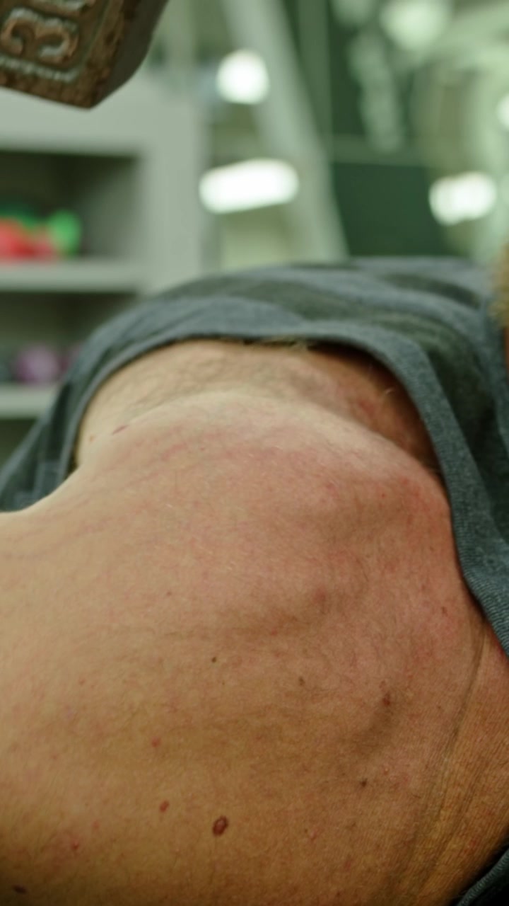 Giovane adulto che si allena strenuamente in palestra