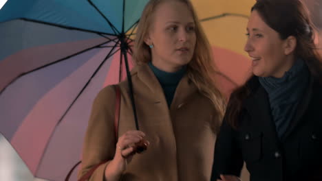 female friends having a walk in rainy evening city