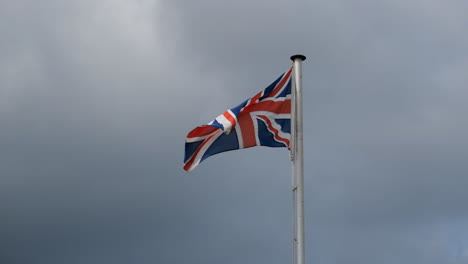 waving union jack british flag of united kingdom waving in a strong wind