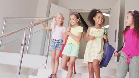 video of happy diverse girls walking downstairs at school and talking