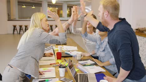 people high fiving in office