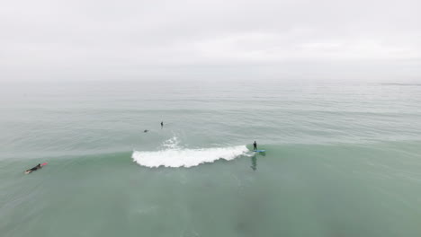 Aerial-flying-over-surfers-along-beach-in-South-Africa