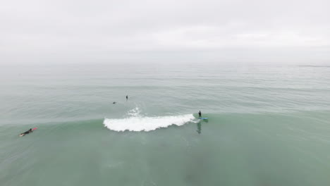 aerial flying over surfers along beach in south africa