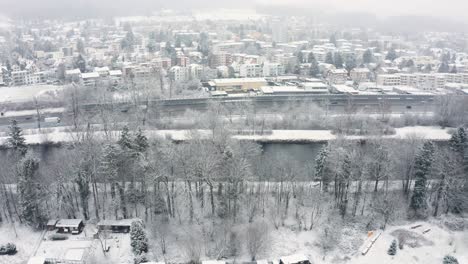a beautiful panning aerial shot of a river, highway, forest and an urban area all in one
